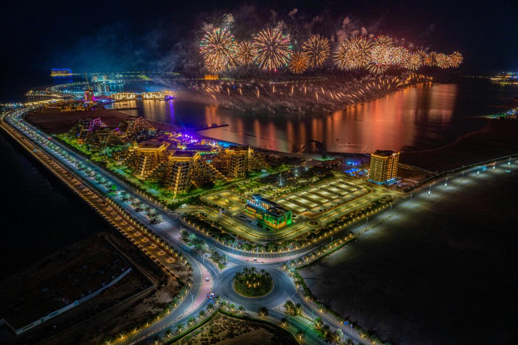 A stunning aerial view of fireworks illuminating Al Marjan Island, UAE at night.